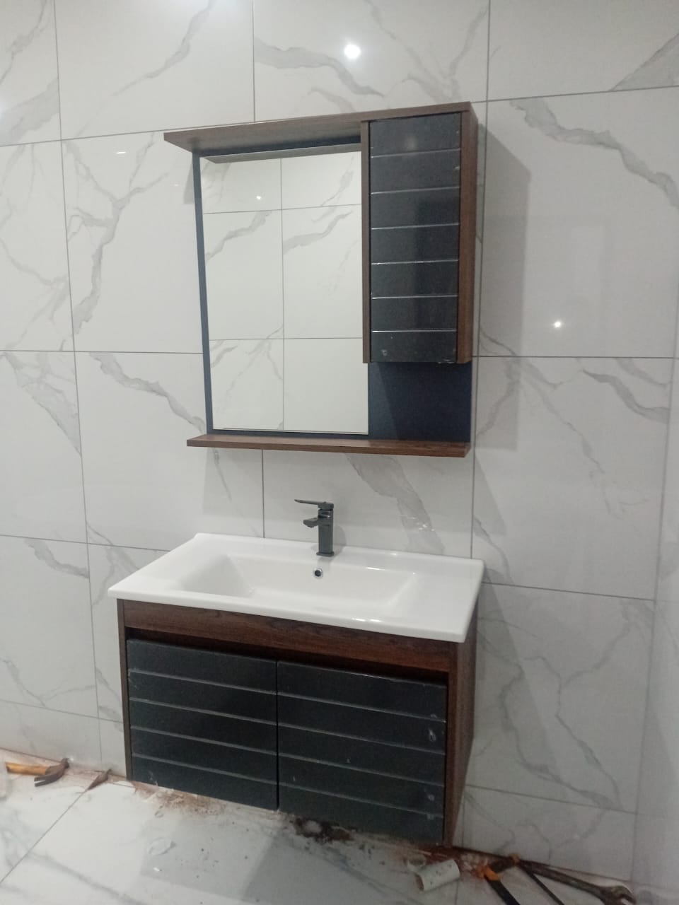 Wall-mounted vanity basin with mirror cabinet installed in a bathroom