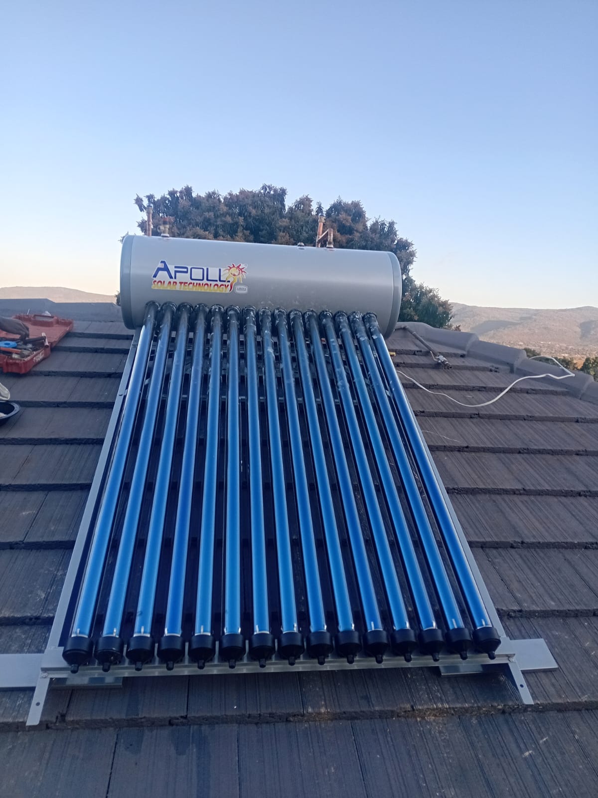 Solar geyser with evacuated tubes installed on a tiled roof by Pfano & Given Plumbing