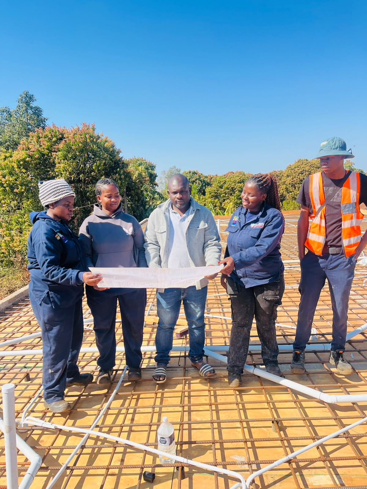 The Pfano & Given Plumbing team reviewing building plans on a new-build roof slab